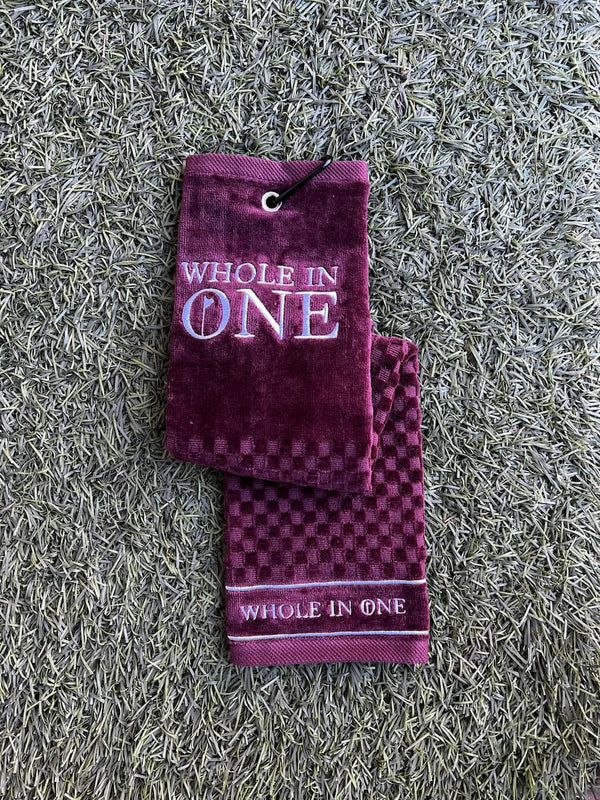 Whole in One merlot golf towel on grass